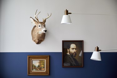 White lamp, taxidermy, vintage art, blue and white wall.